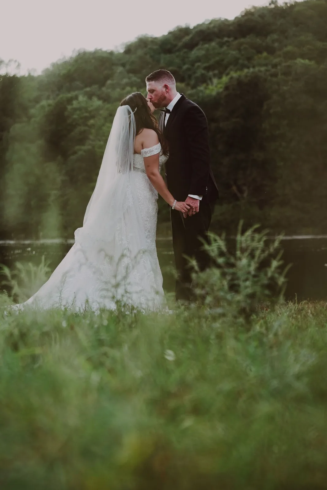 Bride and groom portrait sharing a kiss in a grassy field at dusk — Maximus Visions wedding photography, New Jersey & New York City