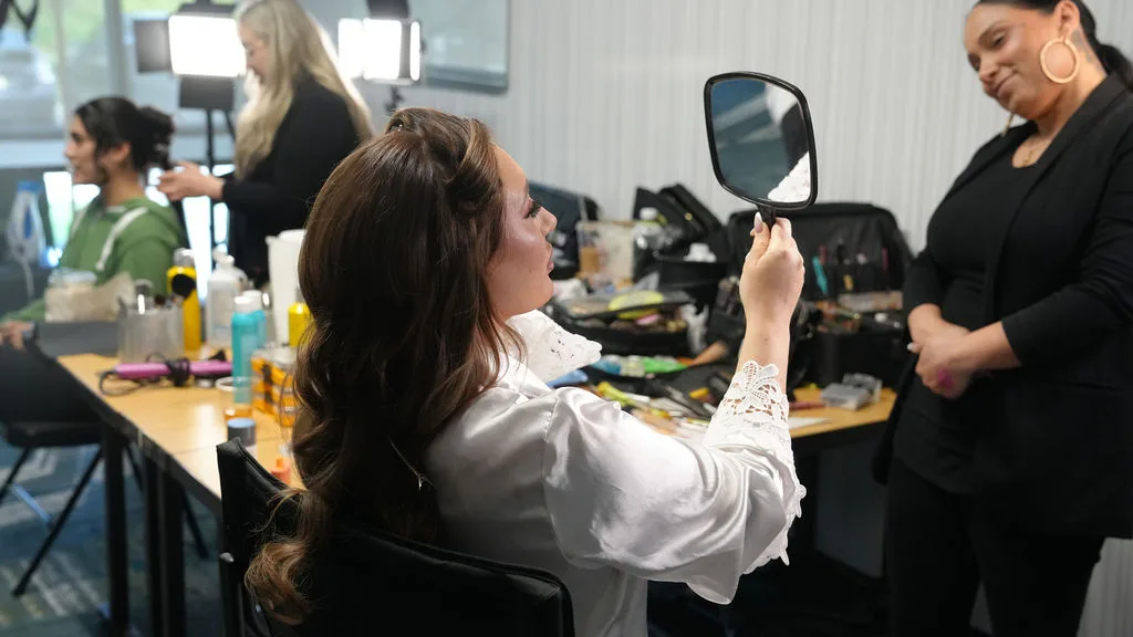 Bride in a white silk robe in the makeup chair on the wedding morning — documentary getting-ready photography by Maximus Visions, New Jersey