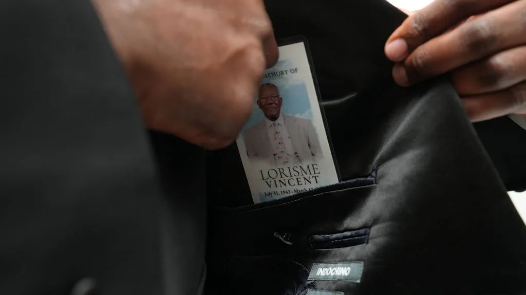 The memorial card is tucked into the tuxedo's inner pocket, carried close for the ceremony — Maximus Visions, New Jersey