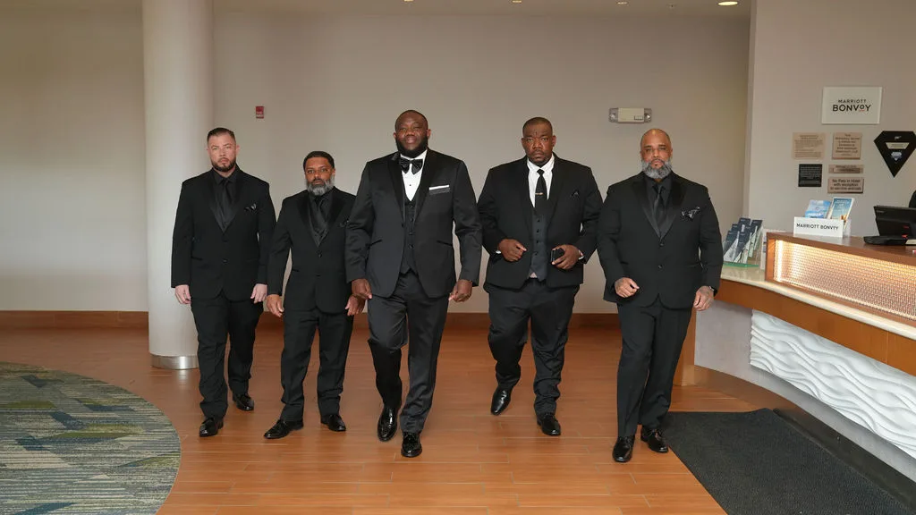 Groomsmen stride through the hotel lobby in formation on the wedding morning, New Jersey