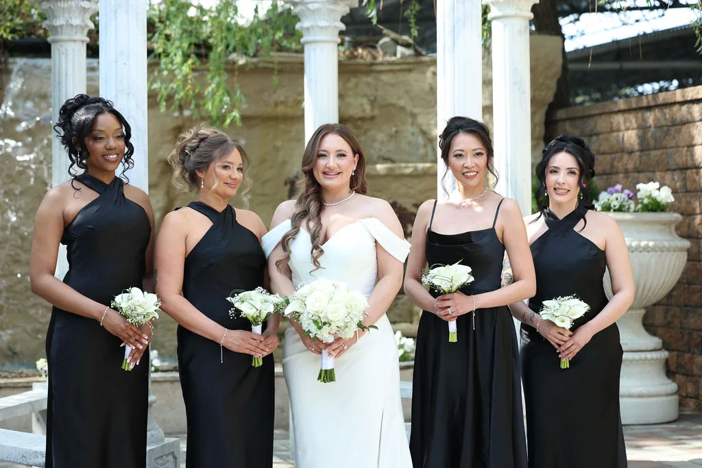 Becky and her bridesmaids in black gowns with white bouquets beneath the marble columns of the ceremony gazebo — formal portrait by Maximus Visions, New Jersey