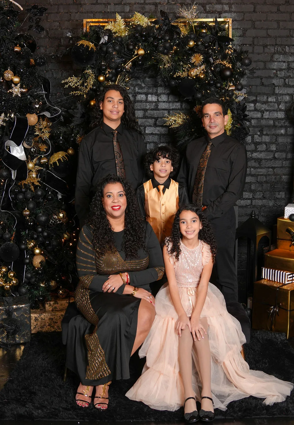 Family of five in coordinated black and gold formal wear posed by a decorated arch — Maximus Visions family portrait session, New Jersey & New York City