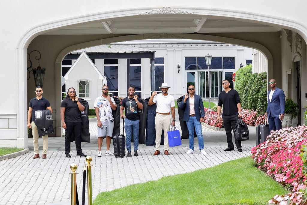 Groomsmen arrive at Park Chateau Estate with garment bags under the porte-cochère, summer wedding morning, New Jersey