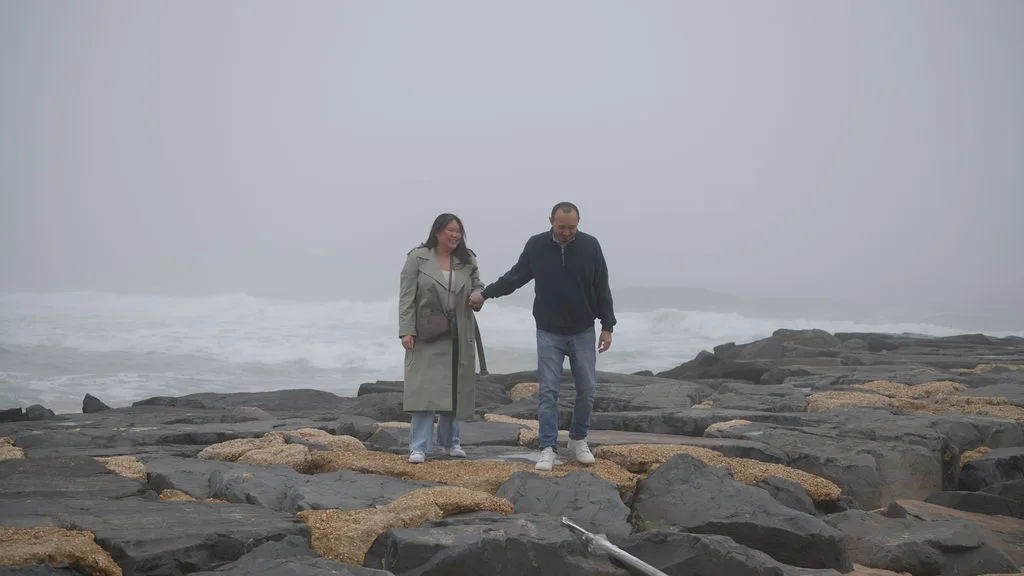 The couple walks the jetty hand in hand, laughing in the sea mist — Maximus Visions, New Jersey