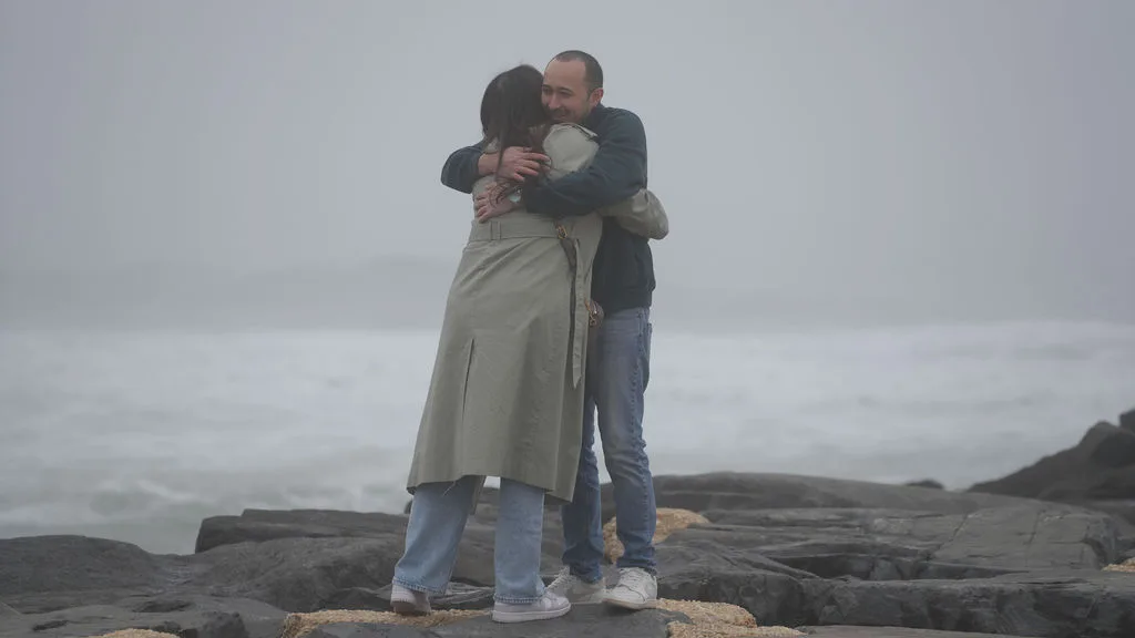 The first embrace after she said yes, wrapped together on the fog-covered jetty — New Jersey shore
