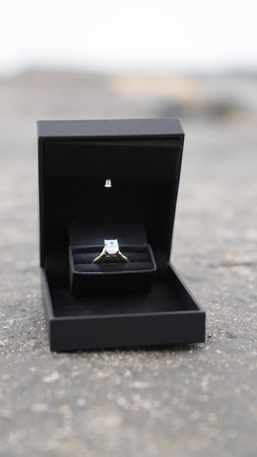 The ring waits in its lit black box on the jetty rocks — surprise proposal detail, New Jersey shore