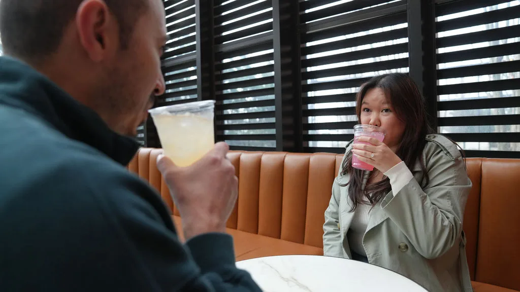 A first toast as an engaged couple, drinks raised in a warm booth out of the fog — New Jersey proposal story by Maximus Visions